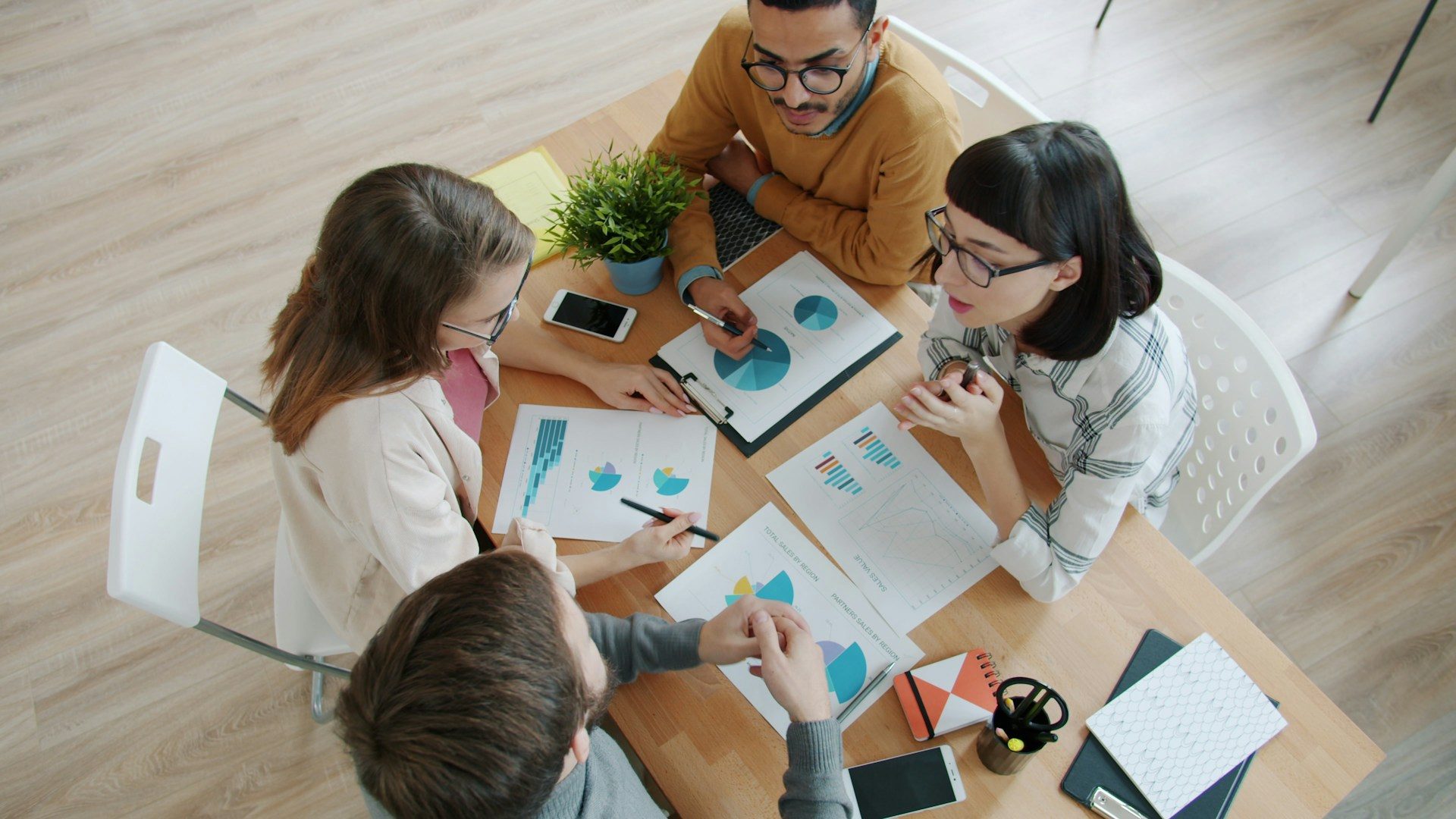 Colleagues reviewing charts and documents around a table